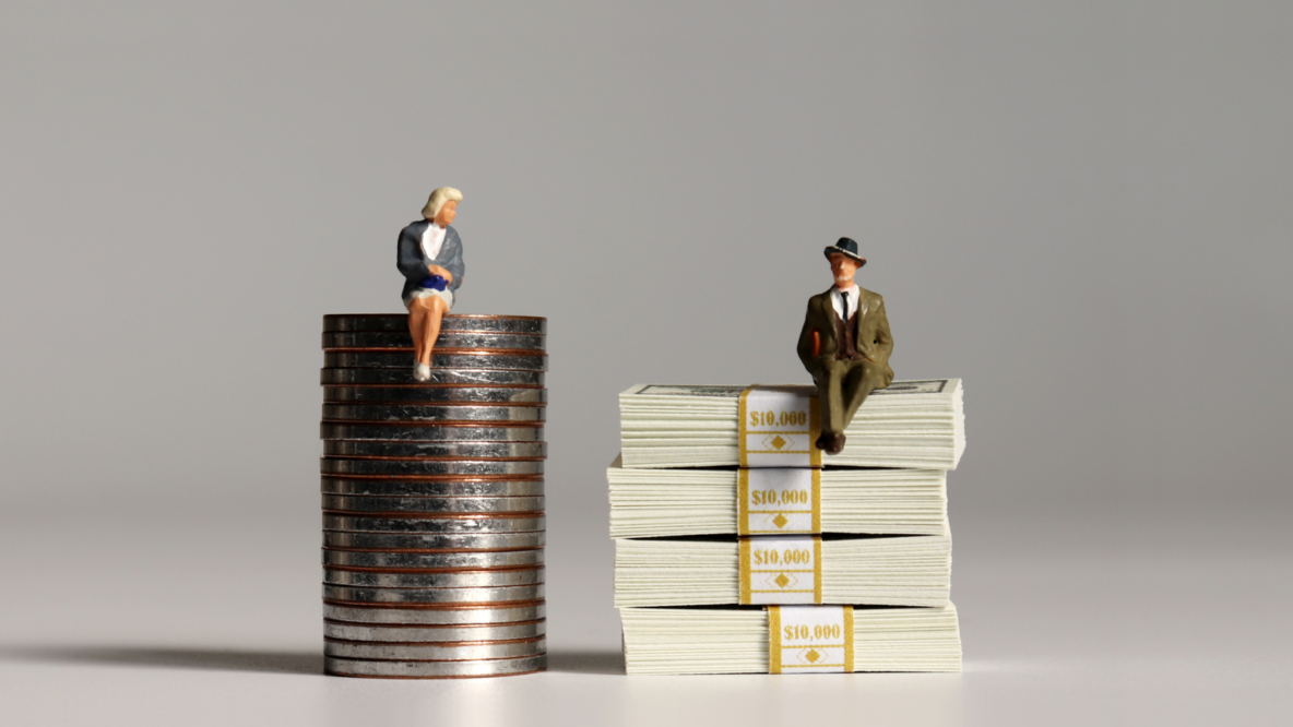 figurines sitting on coins illustrating gender gap