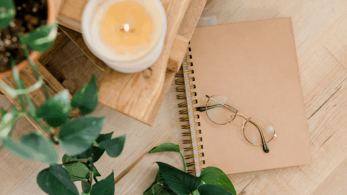 notebook on table with glasses and candle