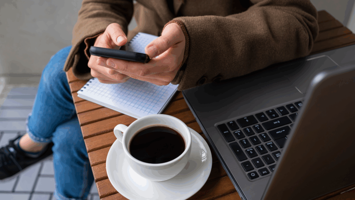 woman sitting with phone laptop and coffee