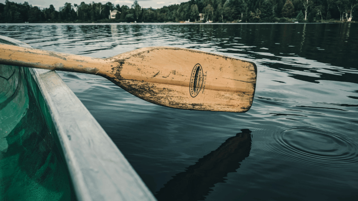 wooden paddle on green boat